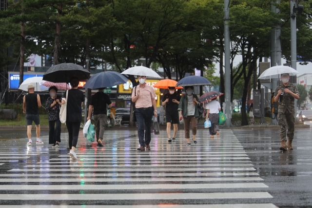 지난 11일 오후 광주 서구 광천동에서 시민들이 우산을 쓰고 퇴근길 발걸음을 재촉하고 있다. 연합뉴스