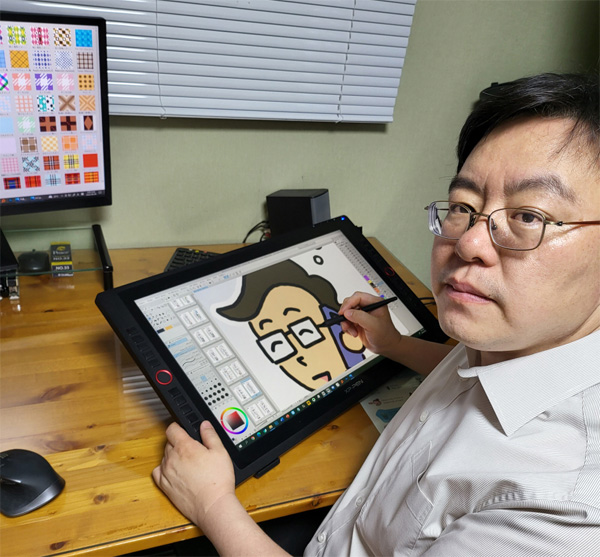 이영욱 변호사가 작업실에서 본인이 그린 만화를 소개하고 있다. [사진 제공 = 이영욱 변호사]