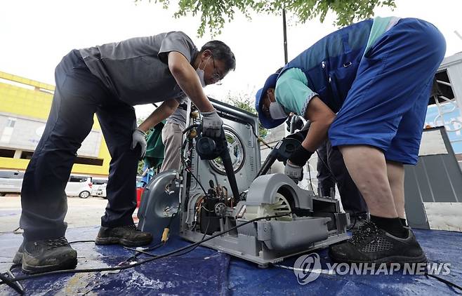 '침수 피해 가전제품 무상수리해드립니다' (서울=연합뉴스) 한종찬 기자 = 15일 서울 관악구 남부초등학교 운동장에서 가전제품 기업 관계자들이 침수 피해를 입은 제품을 수리하고 있다. 행정안전부는 중부지방에 내린 집중호우로 침수 피해를 입은 취약지역에 가전제품 무상수리를 위한 '가전 3사 합동무상수리팀'을 오는 18일까지 운영한다고 밝혔다. 2022.8.15 saba@yna.co.kr