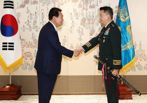 (서울=뉴스1) 오대일 기자 = 윤석열 대통령이 5일 용산 대통령실에서 열린 신임 합참의장 보직 신고 및 삼정검 수치 수여식에서 김승겸 신임 합동참모본부 의장에게 삼정검 수치(끈으로 된 깃발)를 수여한 후 악수하고 있다. 대통령실사진기자단 2022.7.5/뉴스1