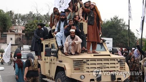 노획한 군용차 위에 올라타고 행진하는 탈레반과 지지자. [UPI 연합뉴스 자료사진. 재판매 및 DB 금지]
