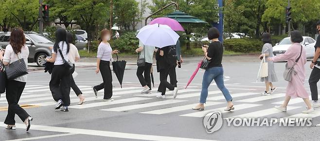 우산 접는 시민들 (광주=연합뉴스) 차지욱 기자 = 16일 오전 광주 서구 치평동에서 시민들이 빗줄기가 가늘어지자 우산을 접고 있다. 2022.8.16 uk@yna.co.kr