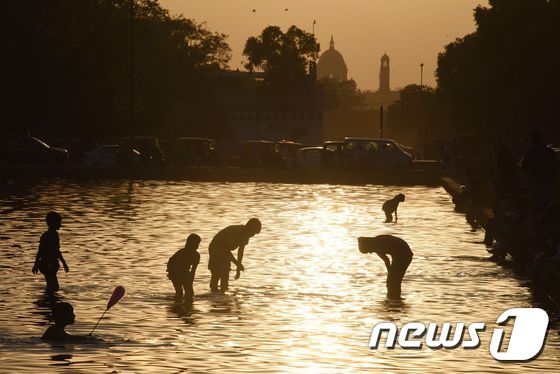 더운 여름날 인도 뉴델리의 강에서 사람들이 목욕하고 있다. ⓒ AFP=뉴스1