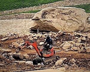 돌과 흙을 가려내는 ‘그물삽’을 장착하고 구산동 고인돌 묘역 안에서 작업 중인 소형 포클레인. 뒤쪽에 세계 최대 규모의 고인돌 상석이 보인다. 중장비를 활용해 묘역 박석들을 정비했다는 의혹을 뒷받침하는 장면이다. 익명의 고고학계 관계자가 <한겨레>에 전달한 고인돌 현장 정비 작업 사진을 확대한 것이다.