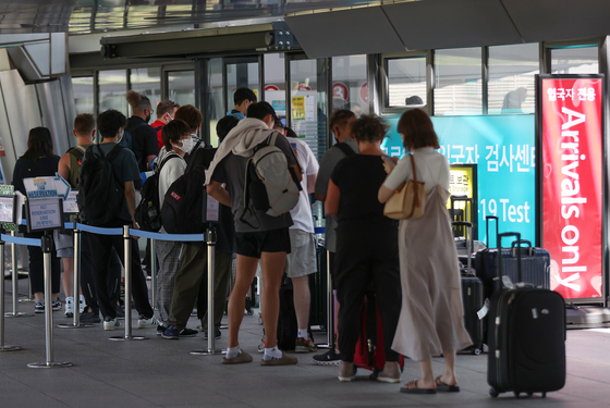 Incoming arrivals wait in line to be tested for Covid-19 at the Incheon International AIrport on Tuesday. [YONHAP]