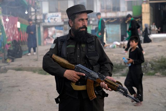 한 탈레반 전사가 지난 7일 아프가니스탄의 수도 카불에서 전날 폭탄테러가 발생한 시아파 무슬림 거주 구역의 경비를 서고 있다. 카불=AP 연합뉴스