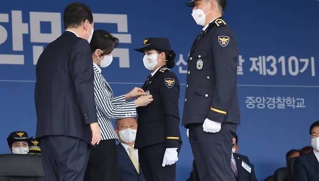 김건희 여사가 19일 충북 충주시 중앙경찰학교에서 열린 310기 졸업식에서 신임경찰에게 흉장을 수여하고 있다.