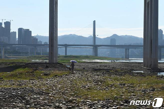 17일 중국 충칭에서 한 여성이 메마른 양쯔강 강바닥을 걷고 있다. 22.08.17 ⓒ 로이터=뉴스1 ⓒ News1 김예슬
