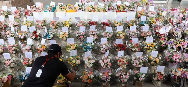 한 배달원이 꽃을 놓고 있다. 뉴시스