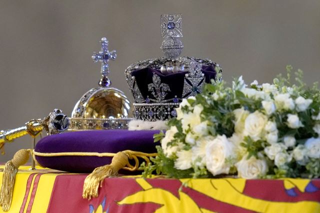16일 엘리자베스 2세 여왕 관 위에 영국 왕실을 상징하는 왕관과 지팡이 모양의 홀이 놓여 있다. AP 연합뉴스
