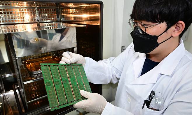 연구원이 반도체 패키징에 전기적 신호를 보내는 패키징 신뢰성 검사를 하고 있다.
