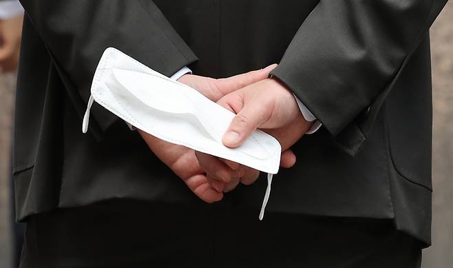 22일 서울 시내에서 한 시민이 마스크를 손에 들고 있다. 정부는 실외 마스크 완전 해제를 포함한 방역 완화책을 이르면 이번주 내 발표할 계획이다. 연합뉴스