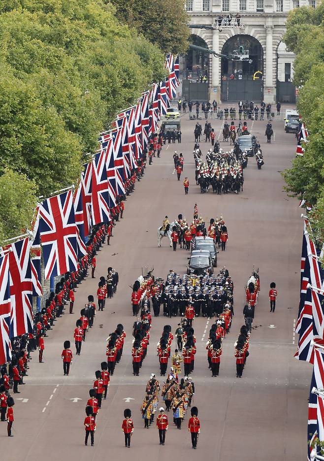 엘리자베스 2세 영국 여왕의 장례식이 엄수된 지난 19일 해군 장병들이 이끄는 포차에 실린 여왕의 관이 런던 버킹엄궁 인근 거리를 지나고 있다. 런던 | AP연합뉴스