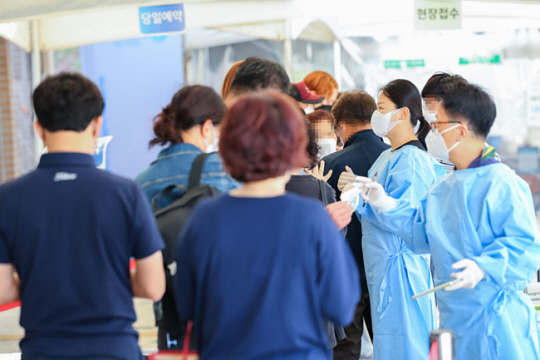 22일 오전 서울 마포구보건소 코로나19 선별진료소를 찾은 시민들이 검사를 위해 줄을 서 있다. 연합뉴스