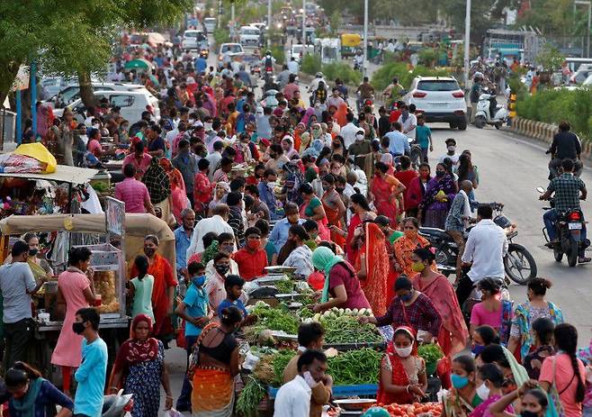 FILE PHOTO: People shop at a crowded roadside vegetable market after authorities eased coronavirus restrictions, following a drop in COVID-19 cases in Ahmedabad, India, June 15, 2021. REUTERS/Amit Dave