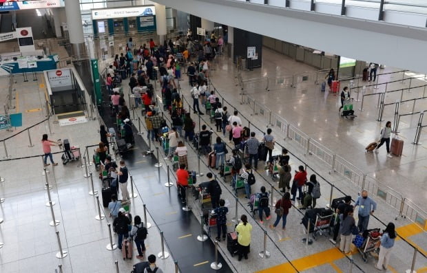홍콩 국제공항에 도착한 여행객들이 격리 호텔로 가는 셔틀버스를 타기 위해 줄지어 서 있다. /사진=로이터