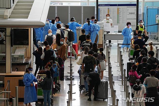 [홍콩=AP/뉴시스] 23일 홍콩 국제공항 입국장에서 승객들이 격리 호텔로 향하는 버스를 기다리고 있다. 존 리 홍콩 행정장관은 오는 26일부터 홍콩 입국자에 대한 호텔 격리 규정을 폐지한다고 밝혔다. 2022.09.23