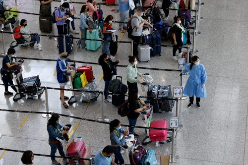 홍콩 국제공항에서 해외 입국자들이 격리 호텔로 가는 버스를 타기 위해 줄을 서 기다리고 있다. 로이터연합뉴스