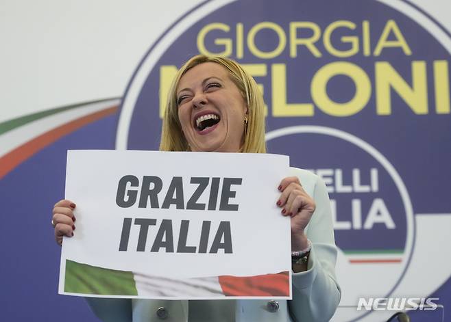 [로마=AP/뉴시스] 조르자 멜로니 이탈리아 형제당 대표가 25일(현지시간) 로마에 있는 당 선거본부에서 "고맙습니다 이탈리아"라고 쓰인 손팻말을 들고 활짝 웃고 있다. 이날 치러진 이탈리아 조기 총선에서 극우 이탈리아 형제당이 주축이 된 우파연합이 승리했다는 출구 조사가 나와 사상 처음으로 여성 총리가 탄생할 것으로 관측되고 있다. 2022.09.26.