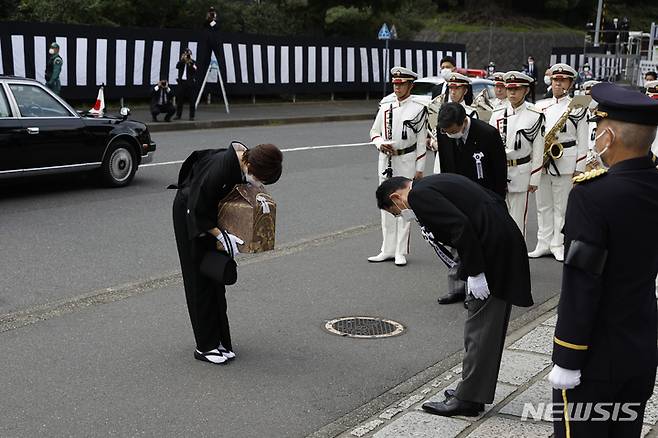 [도쿄=AP/뉴시스] 기시다 후미오 일본 총리(오른쪽)가 27일 고인의 유골을 들고 도쿄 닛폰부도칸 장례식장에 도착한 아베 신조 전 일본 총리의 부인 아베 아키에 여사에게 예를 표하고 있다. 아베 전 총리의 국장이 고인 사망 81일 만에 거행됐다. 2022.09.27.