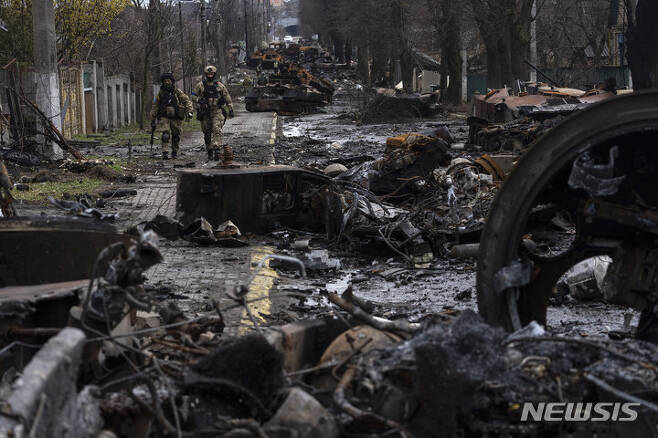 [부차=AP/뉴시스] 3일(현지시간) 우크라이나 부차(Bucha)에서 우크라이나 군인들이 파괴된 러시아군 전차 잔해 사이를 살피며 지나고 있다. 2022.04.04.
