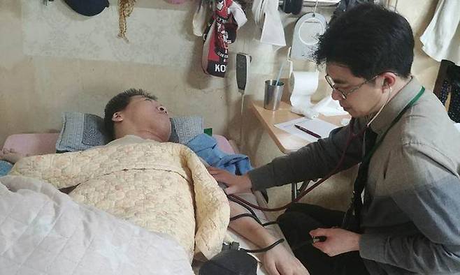 김창오 건강의집 의원 원장이 환자의 집에 방문해 환자의 상태를 살펴보고 있다. 건강의집 의원 제공