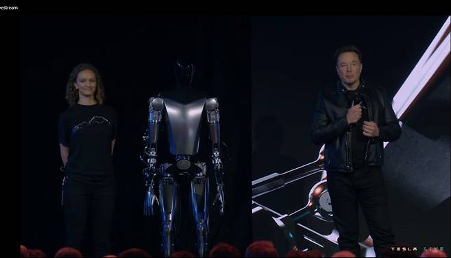 30일(현지시각) 테슬라 AI데이에서 일론 머스크 테슬라 CEO(오른쪽)가 로봇 옵티머스 시제품을 선보이고 있다. /테슬라 행사 캡처