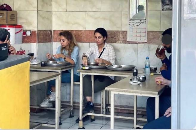 최근 이란 수도 테헤란의 한 식당에서 히잡을 착용하지 않은 채 식사를 하는 도냐 라드(오른쪽) 모습이 담긴 사진이 온라인상에 게재됐다./트위터