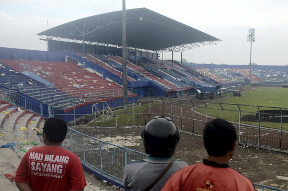 <yonhap photo-2803=“”> People exa</yonhap> - People examine the damage following a soccer match stampede at the Kanjuruhan Stadium in Malang, East Java, Indonesia, Sunday, Oct. 2, 2022. Panic at an Indonesian soccer match after police fired tear gas to to disperse supporters invading the pitch left over 100 people dead, mostly trampled to death, police said Sunday. AP 연합뉴스