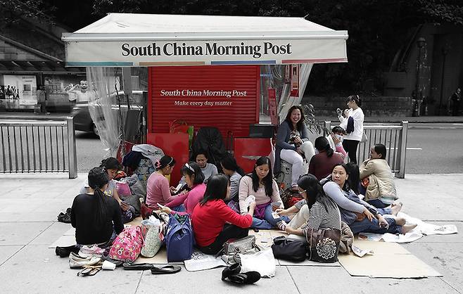 2014년 홍콩의 HSBC빌딩 앞에서 외국인 가사노동자들이 모여 휴식을 취하고 있다. 게티이미지