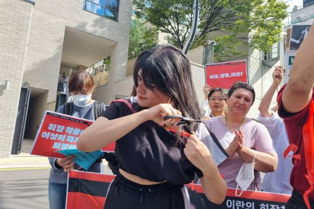 ▲5일 서울 용산구 주한이란이슬람공화국대사관 앞에서 열린 '이란 히잡 관련 시위 한국시민사회단체 지지 기자회견', 머리카락을 자르고 있는 이란 여성 아이샤(Aisa) 씨 ⓒ프레시안(한예섭)