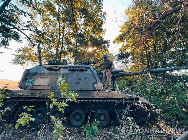 하르키우 지역에서 노획된 러시아군 2S19 자주포를 살피는 우크라이나군 병사 [로이터 연합뉴스자료사진. 재판매 및 DB 금지]
