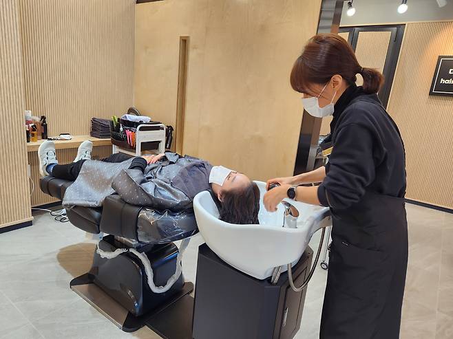 지난 18일 서울 노원구 상계동에 있는 장애인친화미용실 헤어카페 더휴에서 이용객이 머리를 감고 있다. 헤어카페 더휴는 미용의자마다 샴푸대가 설치돼 휠체어를 탄 장애인들도 이동의 불편함 없이 머리를 감을 수 있다. /김태호 기자