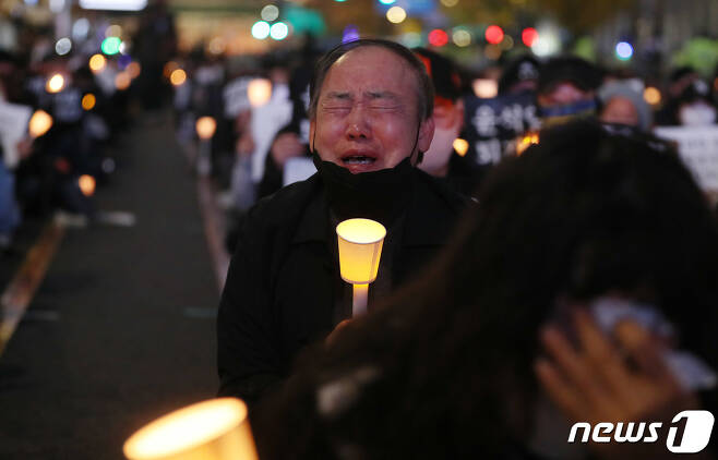 시민들이 5일 오후 서울 시청역 앞에서 열린 이태원 참사 희생자 추모촛불집회에서 촛불을 들며 눈물을 흘리고 있다. 2022.11.5/뉴스1 ⓒ News1 박세연 기자