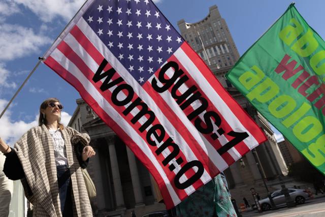 지난달 8일 미국 뉴욕에서 한 시민이 여성의 권리를 요구하는 시위에서 성조기를 들고 있다. 뉴욕=AFP 연합뉴스