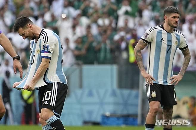 [도하=AP/뉴시스]아르헨티나 축구대표팀 주장 리오넬 메시(왼쪽)가 22일(한국시간) 열린 카타르월드컵 조별 리그 사우디 아라비아와의 경기에서 자신의 유니폼을 보고 있다. 2022.11.22.