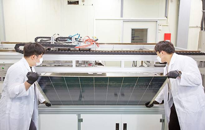 에너지연 연구원들이 유리를 분리 및 회수하기 위해 태양광 폐패널을 개발장치에 넣고 있다.