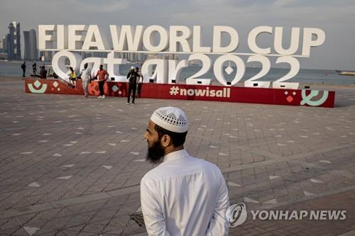 카타르 FIFA 월드컵 2022 표지판 앞에 현지 한 시민이 서 있다. 기사의 특정 내용과 관계 없음. [로이터 연합뉴스 자료사진, 재판매 및 DB 금지]