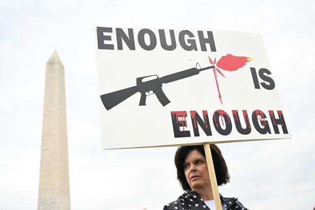 올해 6월 11일 미국 워싱턴 내셔널몰 인근에서 총기 폭력에 반대하는 시위대가 피켓을 들고 행진하고 있다. 워싱턴=AFP 연합뉴스