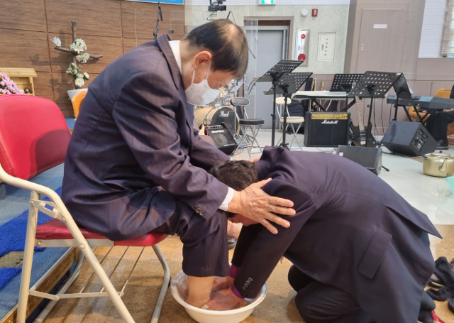 김필수(오른쪽) 목사가 지난 11일 전북 군산 비전교회에서 열린 ‘호남특별연회 원로목사 부부 초청 위로회’에서 한 은퇴 목회자의 발을 씻겨 주며 기도를 하고 있다. 비전교회 제공