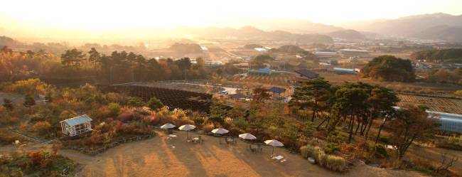 덕유산 서쪽 자락의 언덕 위에 자리 잡은 카페 ‘정원 산책’에서 바라본 전북 무주 안성면 일대의 모습, 분지 형태의 안성면 일대가 눈에 다 들어오는 자리다. 건축가 정기용이 무주프로젝트를 10년 가까이 진행하게 됐던 건 이런 풍경에 반해서였다. 처음 마주친 안성면의 풍경을 두고 정기용은 ‘평생 잊지 못할 풍경이었다’고 책에 적었다.