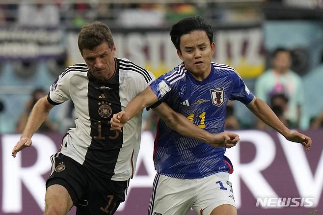 [도하=뉴시스/AP]  일본 대표팀 공격수 구보 다케후사가 2022 카타르 월드컵 조별리그 첫 경기에서  독일 선수와 몸싸움을 벌이고 있다. 2022.11.24