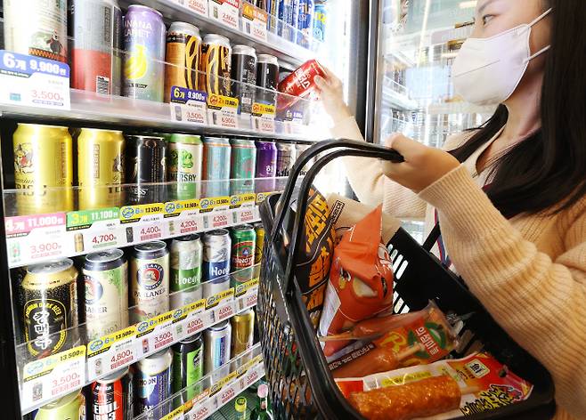 오늘도 월드컵 관전 준비 한 소비자가 25일 서울지역 이마트24 매장에서 맥주와 안주를 장바구니에 담고 있다. 연합뉴스