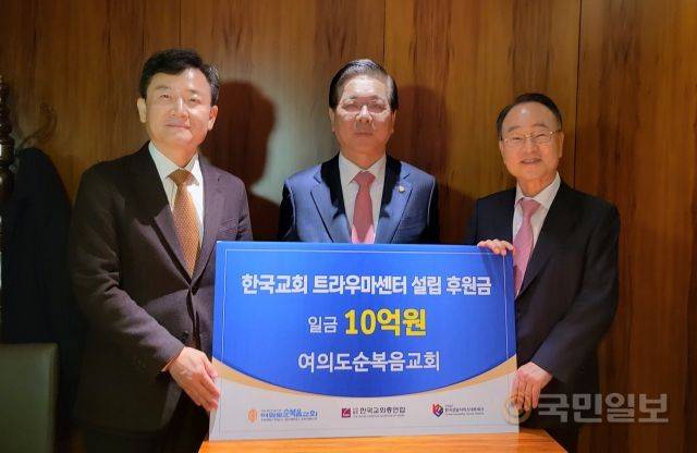 이영훈(가운데) 여의도순복음교회 담임목사가 26일 서울 중구 더플라자호텔에서 한국교회 트라우마센터 지원금 10억원을 류영모(오른쪽) 한국교회총연합 대표회장에게 전달한 뒤 이상억 한국상담네트워크 이사장과 기념촬영을 하고 있다.