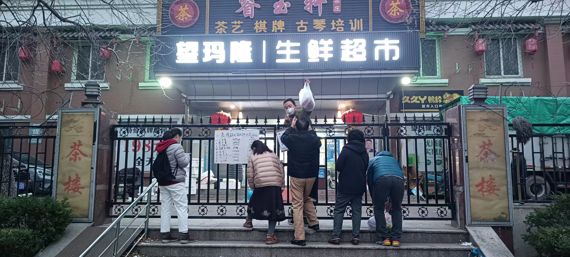28일 오전 중국 베이징 차오양구의 한 아파트에서 주민들이 철문 사이로 생필품을 구입하고 있다. 이 아파트가 봉쇄되면서 내부에서 영업하던 상점으로 출입도 차단됐다. 사진=정지우 특파원