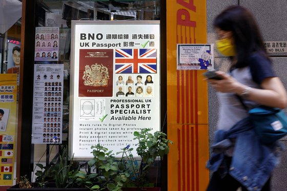 지난 5월 1997년 중국 반환 전 홍콩 주민에게 영국이 발급하는 영국 여권(BNO) 취득을 알리는 안내광고판 옆을 한 홍콩 시민이 지나고 있다. [로이터=연합뉴스]