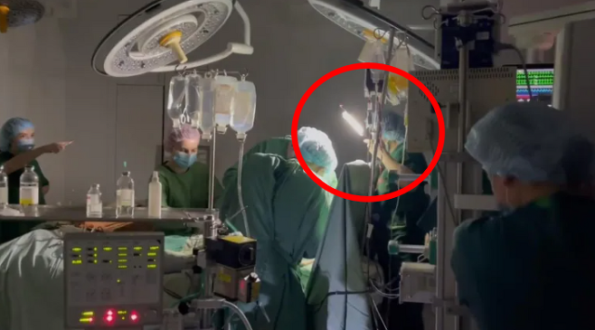 러시아의 미사일 폭격으로 정전된 우크라이나 수도 키이우의 한 병원에서 의료진이 손전등을 든 채 수술을 하고 있다