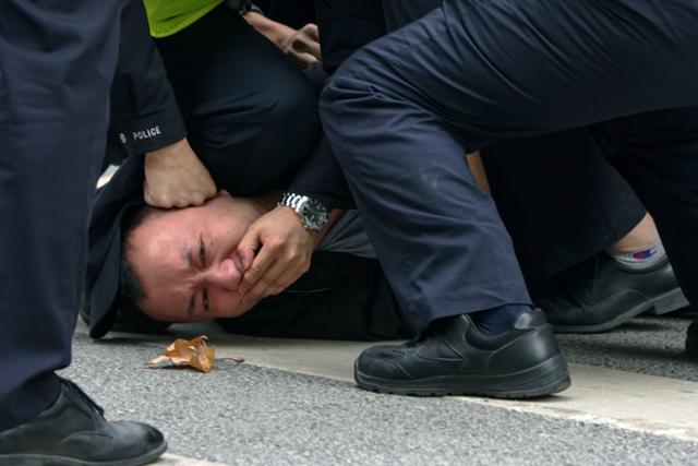 27일(현지시간) 중국 공안이 상하이의 한 거리에서 열린 '제로 코로나' 정책 항의시위 참가자를 제압하고 있다. AP 연합뉴스