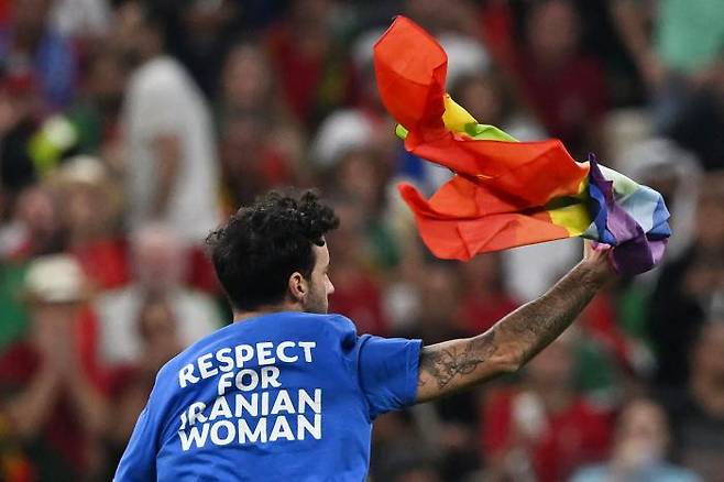 지난달 28일 카타르 루사일 스타디움에서 열린 월드컵 조별리그 포르투갈과 우루과이 경기 도중 한 남성이 그라운드에 난입했다. 이 남성은 이란 여성 인권을 지지하는 티셔츠를 입은 채 무지개 깃발을 들었다. AFP연합뉴스