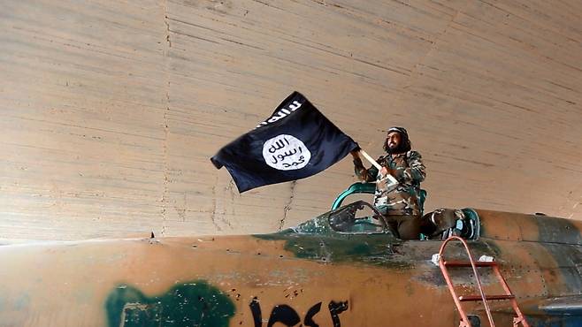 이슬람국가(IS) 대원이 IS 국기를 흔들어 보이고 있다. [게티이미지뱅크]